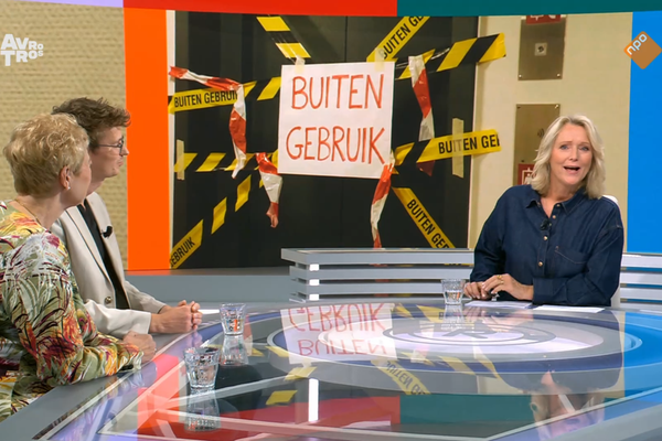 Radar-presentator Antoinette Hertsenberg in de tv-studio met Mathijs ten Broeke van de Woonbond en 50Plus-Kamerlid Corrie van Brenk. Op de achtergrond staat een defecte lift afgebeeld met opschrift 'Buiten gebruik'
